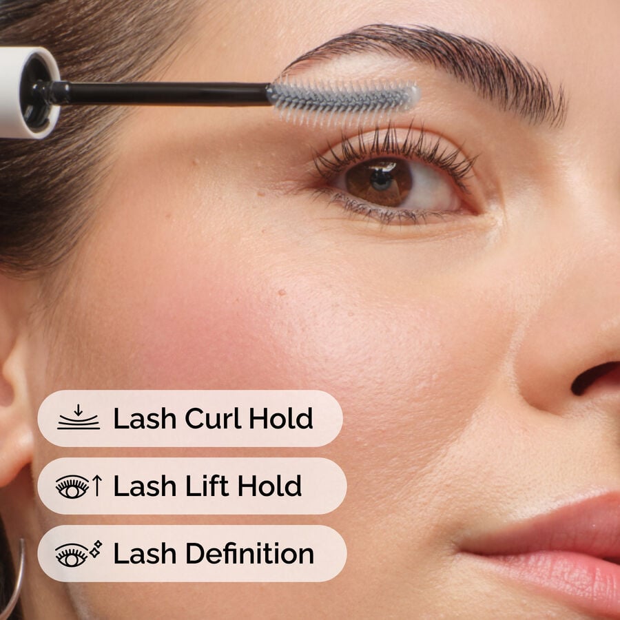 Close-up of a person applying Lash Curl Finisher with its brush to their eyelashes. Text overlays highlight benefits: Lash Curl Hold, Lash Lift Hold, and Lash Definition, showing product efficacy.
